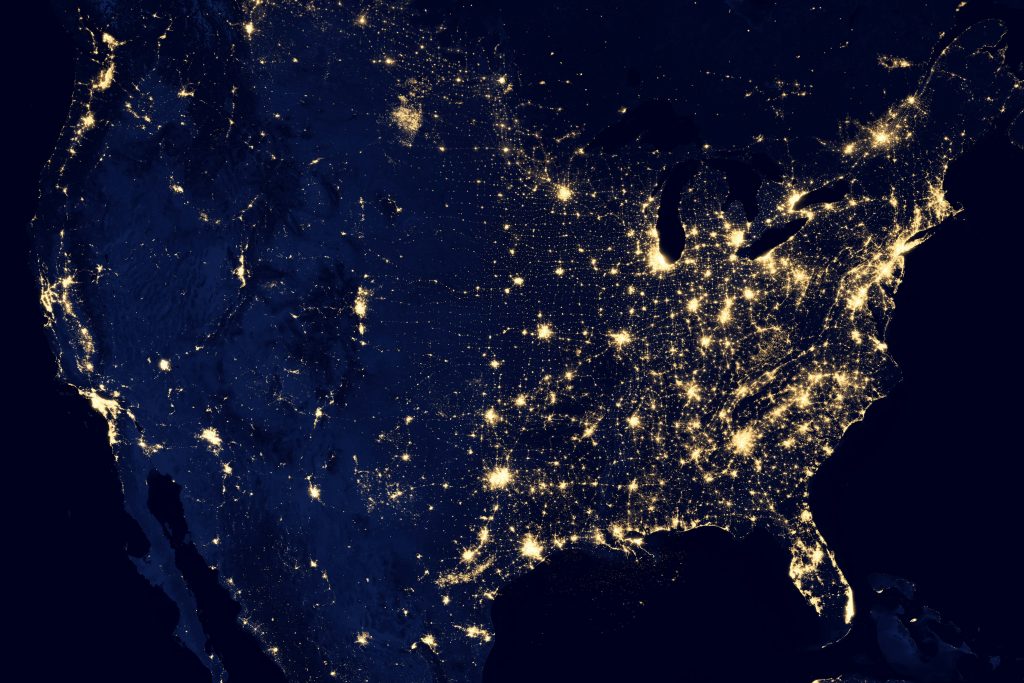 The Earth at night, illuminated by a network of lights.